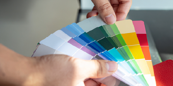 Hand hält Farbfächer mit verschiedenen Farbtönen